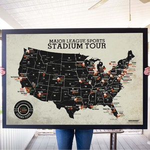 May include: A black and white map of the United States with red, orange, and green dots marking locations. The map is titled "Major League Sports Stadium Tour" and has a vintage look. The map is framed in black.