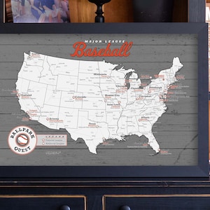 May include: A framed map of the United States with the title "Major League Baseball" and a list of all the Major League Baseball teams. The map is on a gray wood background with a white outline of the United States. The map is surrounded by a black frame.