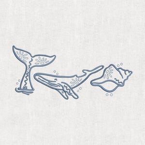 Può includere: Design ricamato blu con una balena, una conchiglia e una coda di balena. La balena e la coda hanno motivi floreali. Anche la conchiglia ha un motivo floreale. Il design è su uno sfondo beige chiaro.