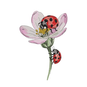 Puede incluir: Diseño bordado con una flor rosa con centro amarillo y dos mariquitas. Una mariquita está en la flor y la otra sube por el tallo. Las mariquitas son rojas con puntos negros y cabezas negras.