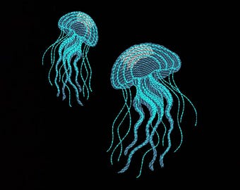 May include: Two jellyfish embroidered designs in vibrant cyan and light blue thread against a solid black background. Each jellyfish features a rounded bell with a cross-hatched pattern and long, flowing, wavy tentacles extending downward.