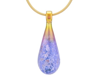May include: A teardrop-shaped pendant necklace with a gold chain. The pendant is made of iridescent glass with a blue and purple color gradient. The glass has a textured surface.