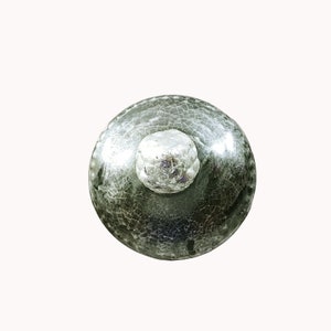 May include: A green ceramic bottle stopper with a silver top. The stopper has a crackled glaze finish.