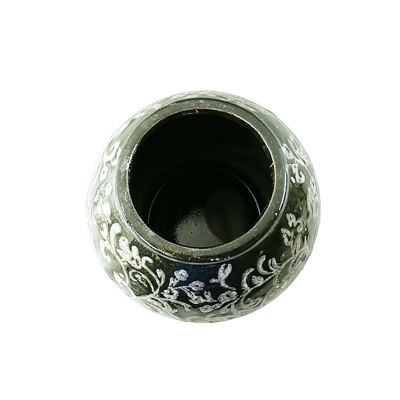 May include: A black ceramic pot with a silver floral design. The pot is empty and has a smooth, glossy finish.