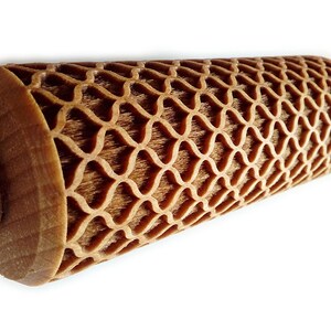 Puede incluir: Un rodillo de madera con un patr&oacute;n de celos&iacute;a decorativo y repetitivo tallado en la superficie de rodadura. Los mangos son lisos y de color claro, mientras que la secci&oacute;n estampada es de un tono marr&oacute;n m&aacute;s oscuro.