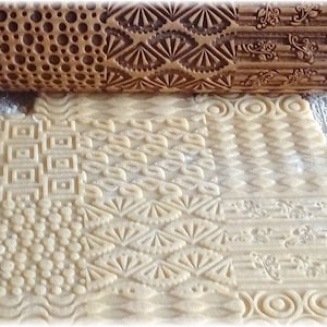 May include: A wooden rolling pin with different engraved patterns is used to create decorative designs on a sheet of dough. The patterns include circles, squares, diamonds, and floral designs.