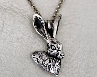 May include: A silver necklace with a detailed rabbit pendant. The rabbit is facing to the right and has a long, pointed nose and ears.