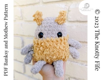 May include: A crocheted plush toy in the shape of a creature with a gray body, yellow legs and arms, and two small antennas. The toy has black eyes and a friendly expression.