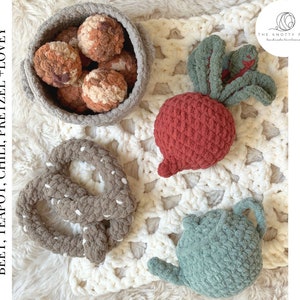 Op de afbeelding: Een verzameling handgemaakte gehaakte items, waaronder een biet, een pretzel, een theepot en een mand met ronde objecten. De items zijn in tinten rood, bruin en groen. De tekst "PDF Crochet Pattern Bundle" is zichtbaar.