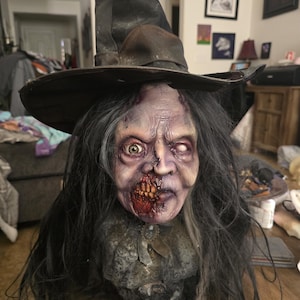 May include: A creepy, detailed, hand-painted, zombie witch bust with a black witch hat, long black hair, and a torn, tattered, lace collar.