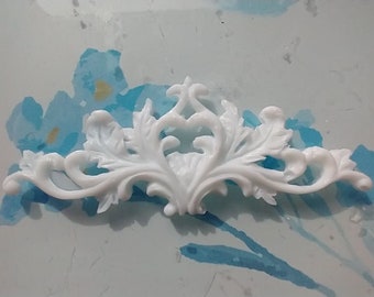 May include: White decorative trim with a floral design. The trim is made of a lightweight material and has a smooth finish.