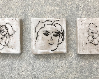 small tiles with faces - pottery