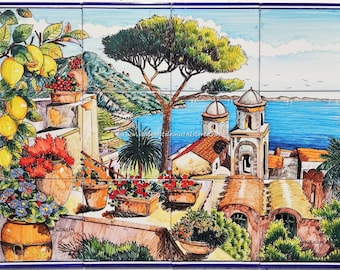 May include: A colorful hand-painted ceramic tile mural depicting a Mediterranean scene with a view of a town, a church with two bell towers, a blue sea, and a green hillside. The scene is framed by potted plants with flowers and lemons.