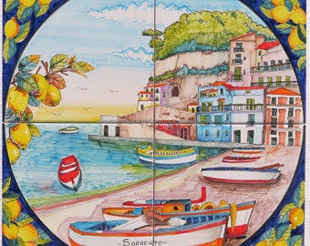 May include: A colorful ceramic tile depicting a seaside scene with boats, buildings, and lemon trees. The tile is decorated with blue and white trim and features the text "Sorrento" in a cursive font.