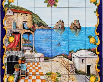 May include: A colorful ceramic tile mural depicting a Mediterranean scene with a blue sea, rocky islands, a white building, and a lemon tree. The tile mural is divided into nine squares.