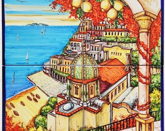 May include: A colorful ceramic tile depicting a scene of Positano, Italy. The tile features a yellow and green dome building with a red roof, surrounded by colorful buildings and a blue sea. The tile is decorated with lemon trees and a white column with a blue and white striped base.