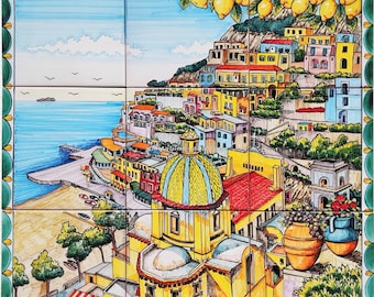 May include: A colorful ceramic tile mural depicting a seaside town with a yellow church, a blue dome, and a lemon tree. The town is built on a hillside with colorful buildings and a blue sea in the background.