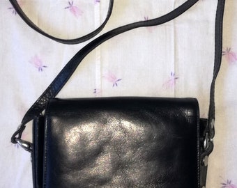 May include: A black leather crossbody bag with a silver buckle and the word "JOCKEY" embossed on the front.