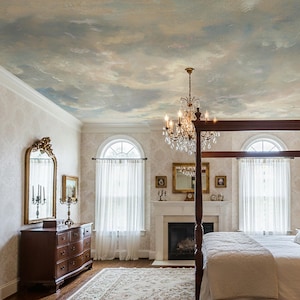 May include: A luxurious bedroom featuring a four-poster bed, a fireplace, and a chandelier. The ceiling is painted with a sky mural. The room has a classic, elegant design with a large mirror and a wooden dresser.