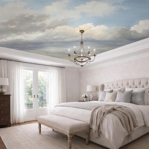 Peut inclure: Chambre avec plafond peint représentant un ciel nuageux. La pièce comprend un grand lit avec une tête de lit capitonnée, un lustre et une commode en bois. Des rideaux blancs encadrent des portes-fenêtres et un banc est au pied du lit.
