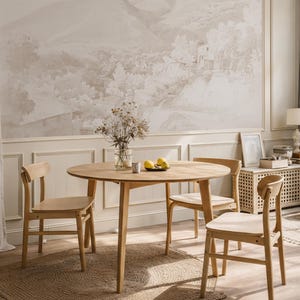 May include: A light wood dining table with four matching chairs. The round table is set on a woven rug, with a vase of dried flowers and lemons as a centrepiece. The room has a neutral colour palette.