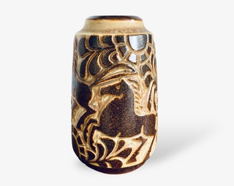 Peut inclure: Un vase en céramique brun et beige avec un motif floral. Le vase est de forme cylindrique et a une finition lisse et glacée.