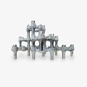 Può includere: Un candelabro argentato a più livelli con un design strutturato e organico. Il candelabro ha più bracci e spazi per candele, creando un'esposizione unica e artistica. Il design ricorda una scultura moderna.