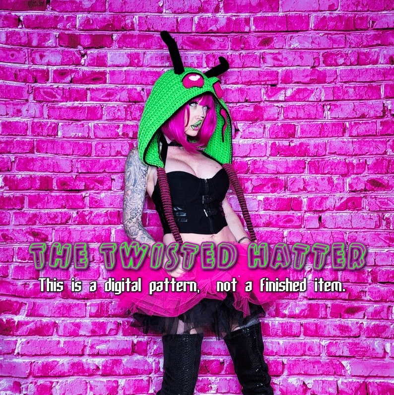 May include: A woman wearing a green and pink hooded hat with a creature design, a black top, a pink tutu, and black boots. The background is a pink brick wall. The text "THE TWISTED HATTER" and "This is a digital pattern, not a finished item." is displayed below the woman.