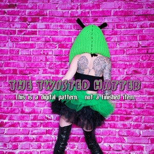 May include: A crochet pattern for a green and black twisted hatter costume. The pattern includes a green hat with antennas and a black and green tutu. The text "THE TWISTED HATTER" and "This is a digital pattern, not a finished item." is visible in the image.