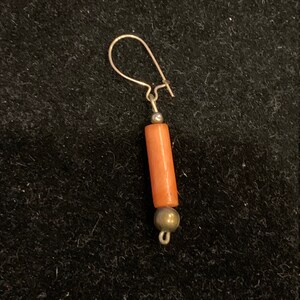 Peut inclure: Une seule boucle d'oreille en corail orange avec des accents argentés et un crochet argenté.