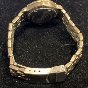 Peut inclure: Une montre argent&eacute;e et dor&eacute;e avec un bracelet en m&eacute;tal argent&eacute;. Le cadran de la montre n'est pas visible sur l'image.