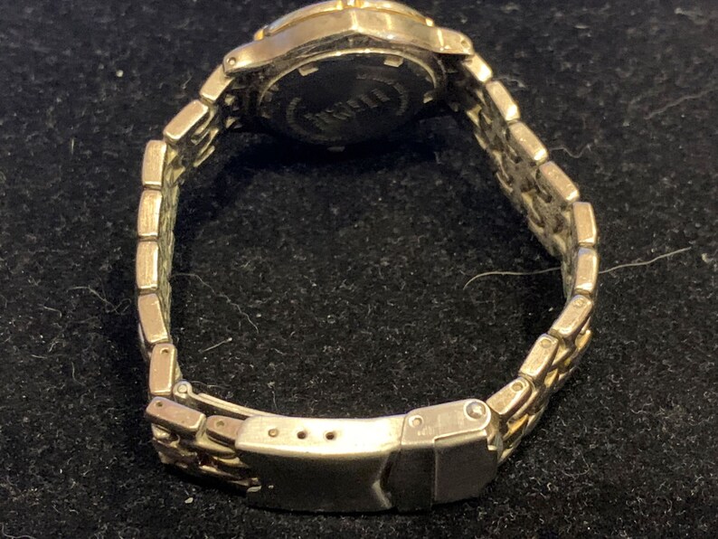 Peut inclure: Une montre argent&eacute;e et dor&eacute;e avec un bracelet en m&eacute;tal argent&eacute;. Le cadran de la montre n'est pas visible sur l'image.