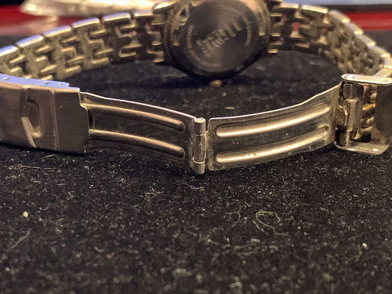 Peut inclure: Un bracelet de montre argent&eacute; avec un fermoir &agrave; double verrouillage. Le bracelet est compos&eacute; de maillons m&eacute;talliques et a une finition polie.