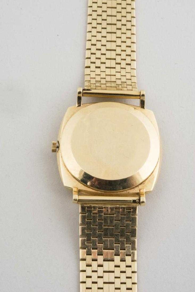 May include: A gold-tone wristwatch with a square face and a gold-tone metal band. The watch has a plain back.