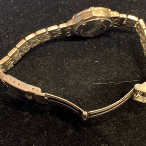 Peut inclure: Une montre argent&eacute;e avec un bracelet en m&eacute;tal argent&eacute;. La montre a un cadran rond et un fermoir argent&eacute;.