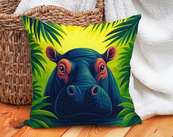 May include: Square decorative pillow featuring a vibrant illustration of a hippo's face. The hippo is depicted in shades of blue and teal, with orange accents, surrounded by lush green foliage against a yellow background. The pillow is likely made of soft fabric.