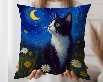 May include: A square decorative pillow featuring a black and white cat gazing upwards under a crescent moon and starry night sky. The cat is surrounded by daisies and yellow flowers, set against a deep blue background.