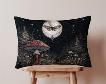 May include: A decorative rectangular pillow featuring a whimsical forest scene. A large red mushroom with white spots is in the foreground. A moth is centered in front of a full moon, with a starry night sky background.