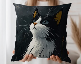 May include: A decorative square pillow featuring a stylized illustration of a black and white cat with blue eyes looking upwards. The cat has yellow ears and long white whiskers. The background is dark with hints of gold.
