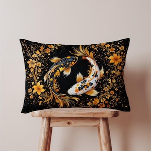 May include: Rectangular black pillow featuring two koi fish in a circular design. One fish is black with yellow floral accents, the other is white with black and orange accents. The design is surrounded by gold floral elements.