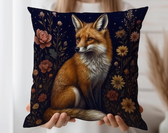 Può includere: Un cuscino quadrato decorativo con un'illustrazione dettagliata di una volpe con pelliccia arancione e bianca, su uno sfondo blu scuro con fiori. Il cuscino presenta un motivo floreale con rose e altri fiori.
