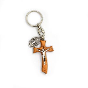 May include: A wooden cross keyring with a silver Jesus figure and a silver Saint Christopher medal. The keyring is attached to a silver key ring.