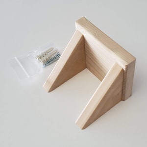 May include: A natural wood shelf with a triangular design, perfect for displaying small items. It comes with mounting hardware for easy installation.