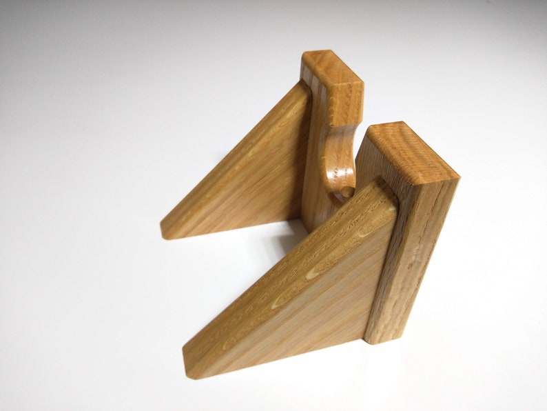 May include: A wooden stand with two angled shelves, designed to hold a record player. The stand is made of light brown wood with a natural grain.