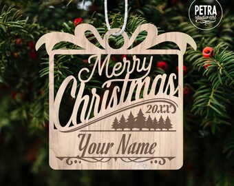 May include: A wooden Christmas ornament shaped like a gift box with a bow. The ornament has the text "Merry Christmas 20XX" and "Your Name" on it.