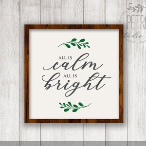 May include: A white sign with a brown wood frame, featuring the text "All is calm, All is bright" in grey cursive font. The text is surrounded by two green leafy sprigs.
