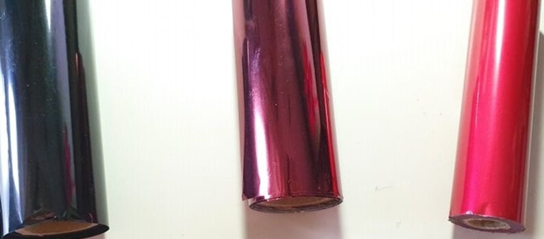 May include: Three rolls of metallic foil in black, red and pink.