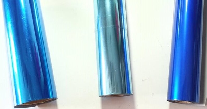 May include: Three rolls of metallic blue foil, one with a light blue hue, one with a darker blue hue, and one with a bright blue hue.