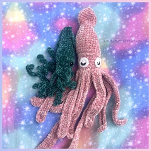 May include: Two plush squid toys made of soft velvet yarn. One is dark green and the other is light pink. Both have long tentacles and embroidered eyes. The text "underwatercircus" is visible on the right side of the pink squid toy.