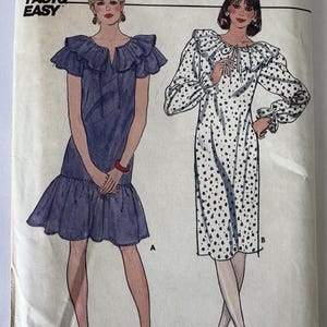 May include: Vintage Butterick sewing pattern featuring two dress designs. One dress is a solid blue with a ruffled neckline and hem. The other is a white dress with black polka dots, a ruffled neckline, and long sleeves. The pattern size is 8-10-12.